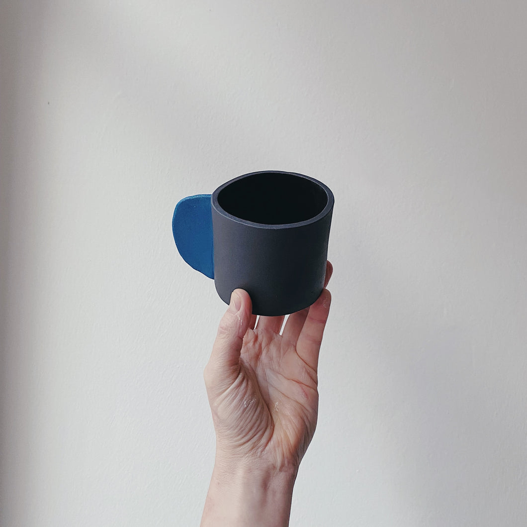 Black mug with blue handle