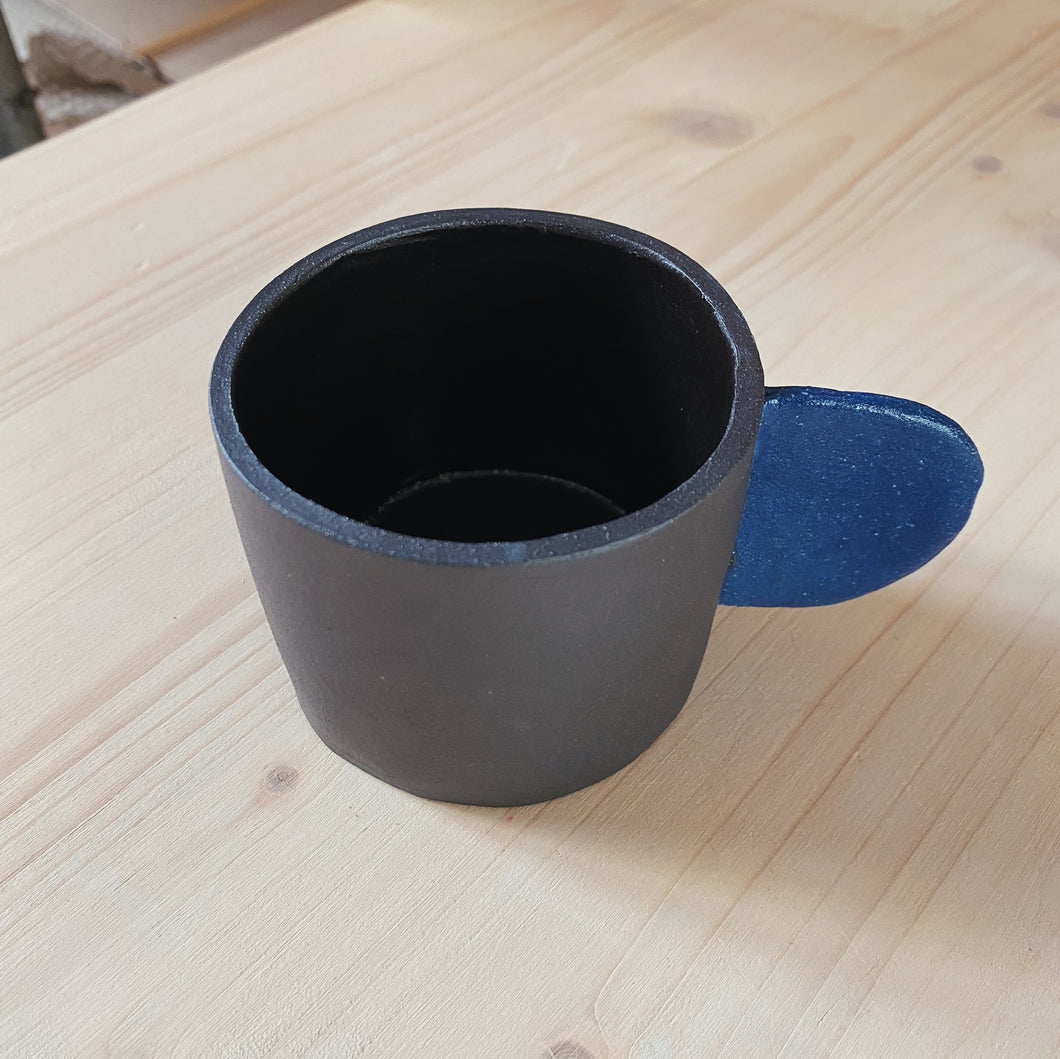 Kleine Tasse schwarz mit blauem Henkel 2