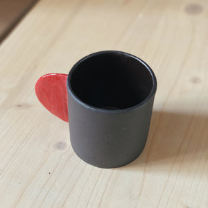 Tasse schwarz mit rotem Henkel